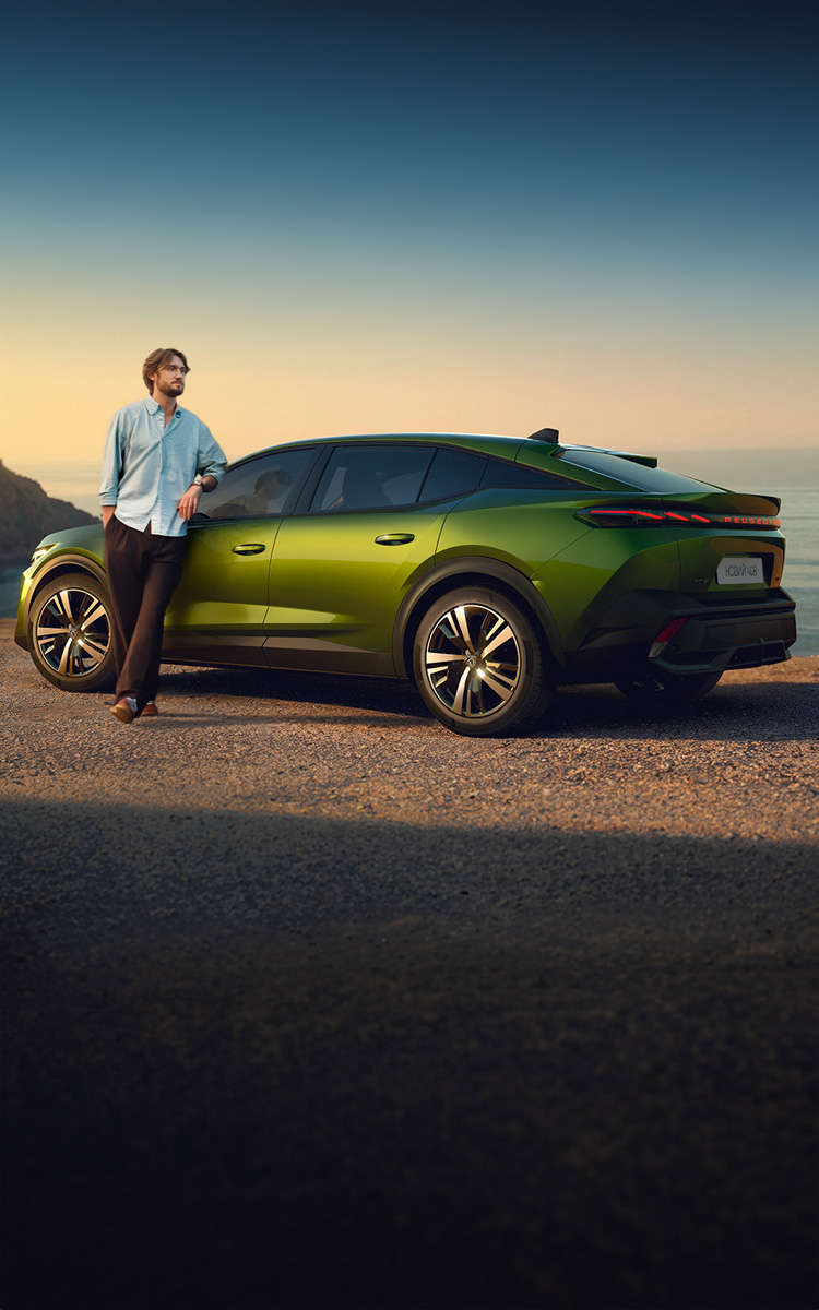 ерівник хору «Гомін» Вадим Яценко біля Peugeot 408 зеленого кольору на грунтовій дорозі біля моря